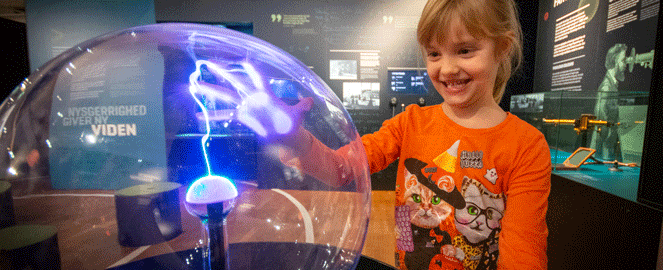 Girl touching the plasma globe in the exhibition The inquisitive mind 